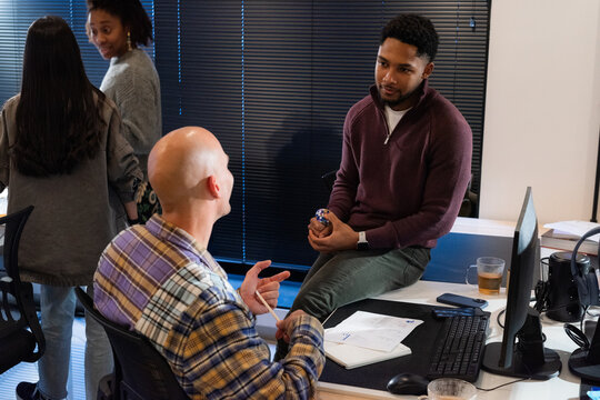 Discussion Happening Between Coworkers in Modern Office Setting