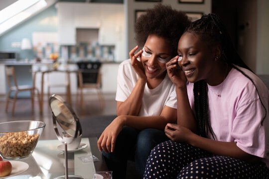 Delighted multiethnic women doing skin care routine