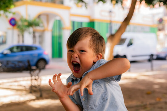 Child Plays and Poses in Park During Sunny Day