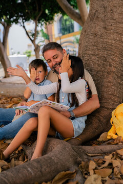 Father playing with kids at park 