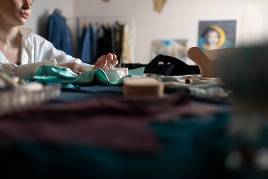 Cropped lady sewing with needles in home office
