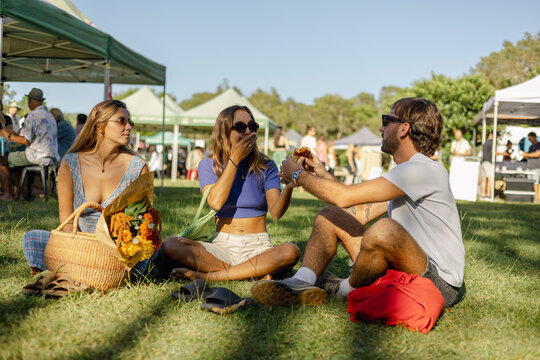 Friends Eating Food at Market in Byron Bay, Australia