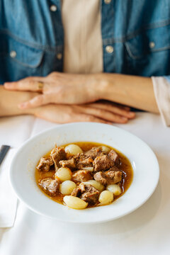 Lamb stew with pearl onions served at table