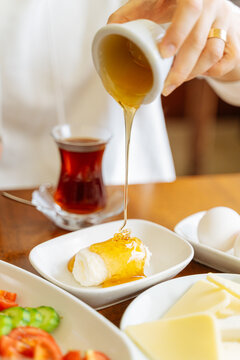 Honey poured over clotted cream during breakfast