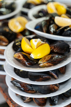 Plates of stuffed mussels with lemon wedges