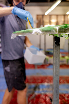 Shaper trimming laps during glassing in  Australia
