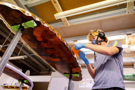 Shaper laminating surfboard in Australia