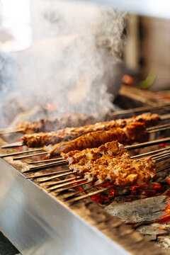 Assorted kebabs grilling over hot charcoal
