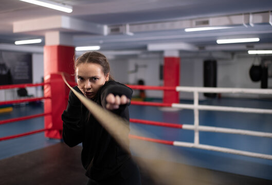 Serious female boxer practicing jabs during training
