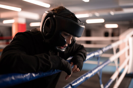 Tired female boxer resting after fight