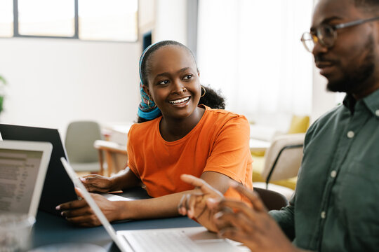 Smiling Woman Talks to Man in Office Setting During Day