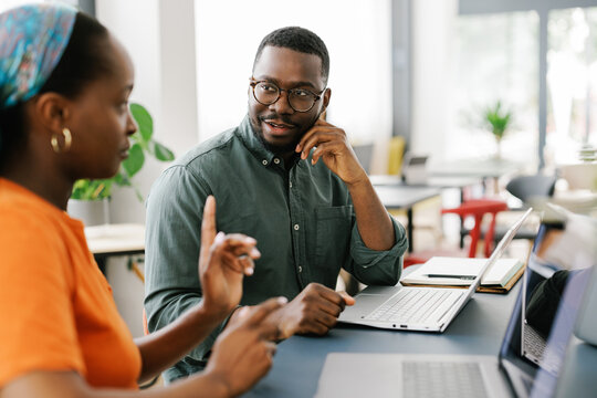 Two People Discuss Ideas During a Meeting in a Bright Office