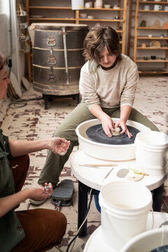 Kid learning pottery on wheel