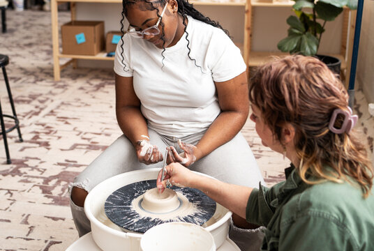 Instructor demonstrating pottery wheel technique