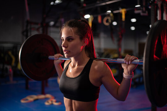 Strong woman lifting heavy barbell