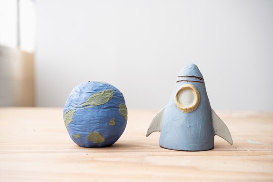 Handmade clay planet and rocket sculptures