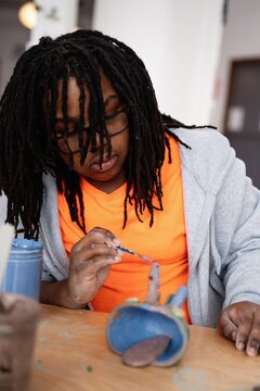 Student Painting Clay Sculpture