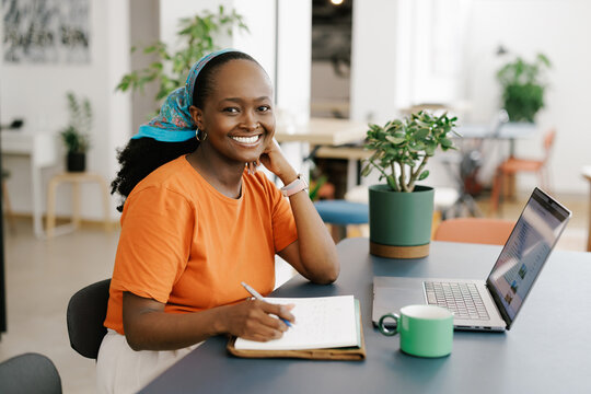Young Black Woman Working on a Laptop in bright office 