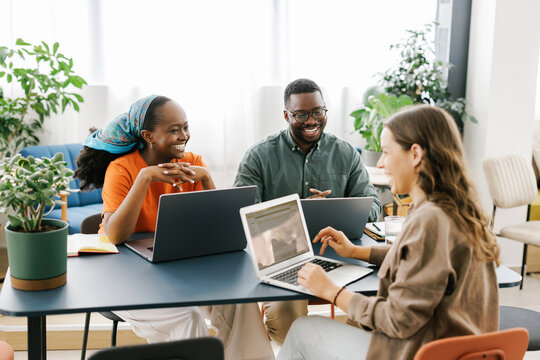 Diverse group of young people studying together in cafe 
