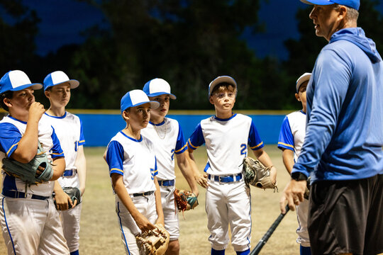 Young Baseball Team Trains at Night on the Diamond