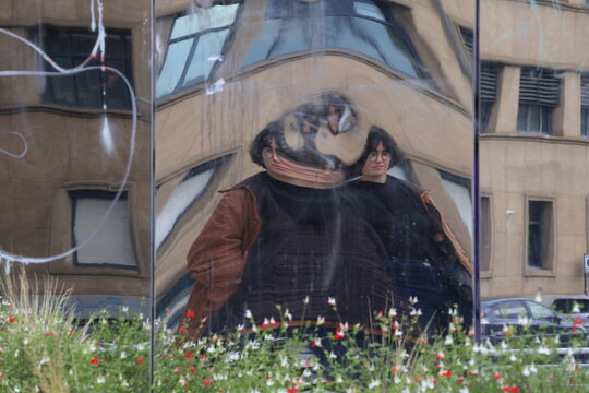 Distorted reflection of a woman in a building office wall