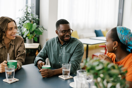 Friends Enjoy Drinks and Conversation in a Cafe Setting