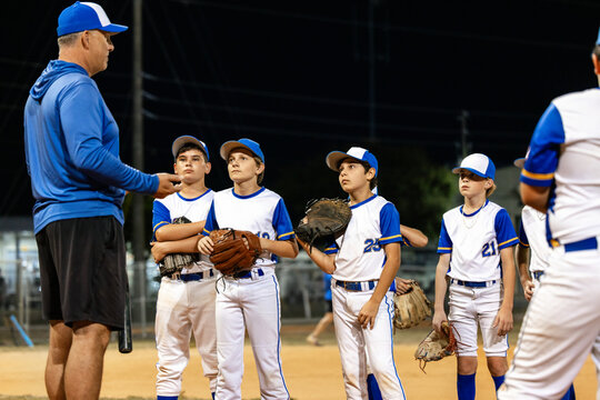Youth Baseball Team listening coach instructions