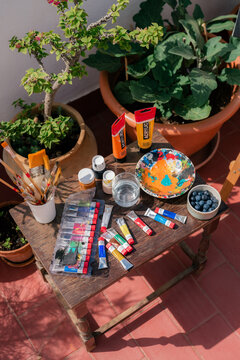 Art Supplies Arranged on a Wooden Table in a Garden Setting