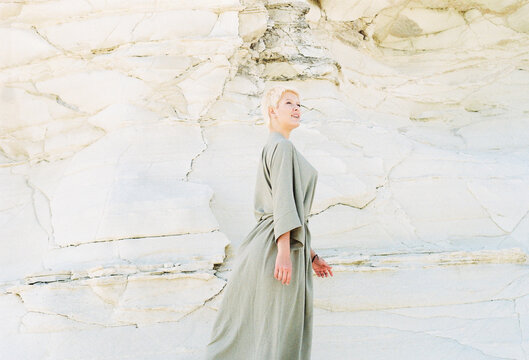Woman Walking Near White Rock Formation During Daylight Hours