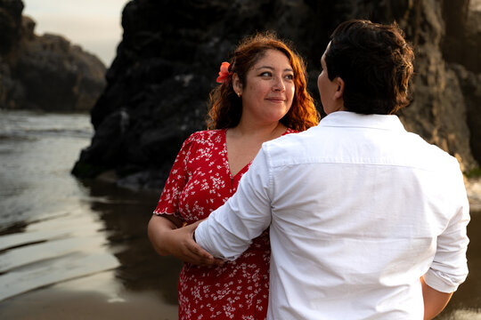 Young Couple Embracing on Beach at Sunset