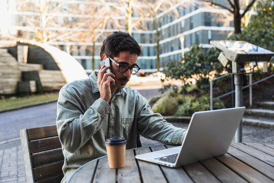 Title: Focused Remote Worker Talking on Smartphone