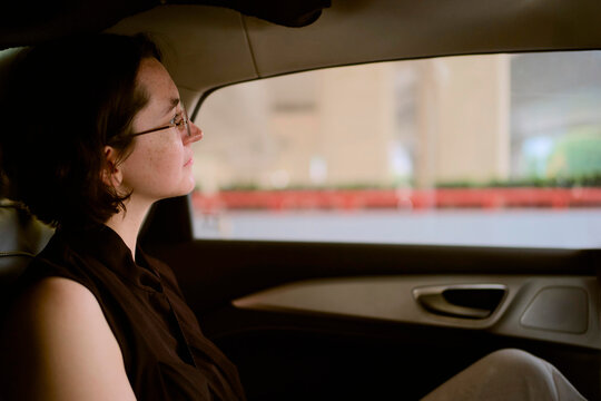 Woman Sitting in a Car Looking out the Window During Daytime