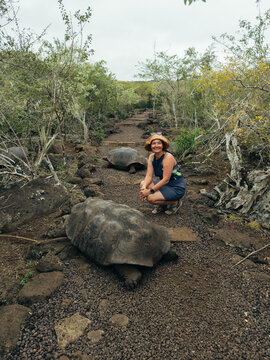 Woman Crouching Near Giant Tortoise on Trail