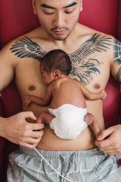 Father doing skin-to-skin kangaroo care with newborn baby