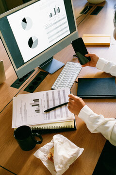 Businesswoman Checking Smartphone During Work Lunch at Desk