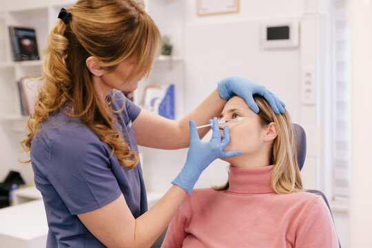 A doctor is applying botox at a patient