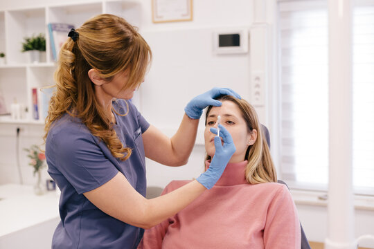 A doctor is applying botox at a patient