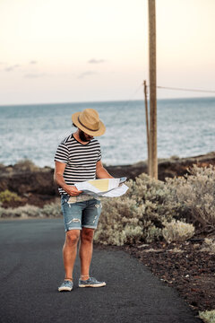 Traveler man navigating map on coastal road trip