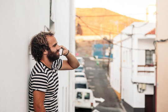 Young man talking on phone standing on urban street