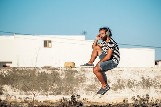 Young man enjoying music outdoors, finding solitude and relaxation
