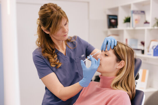 A doctor is applying botox at a patient