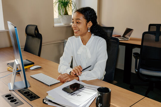 Smiling Businesswoman Working at Computer Desk in Modern Office