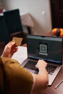 Person uses card next to laptop for online shopping
