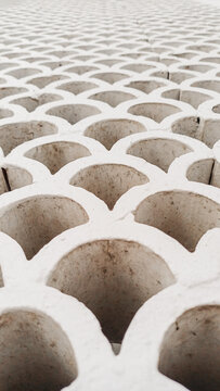 White breeze block wall with a repetitive curved pattern. Modern geometric concrete ventilation roster texture for background