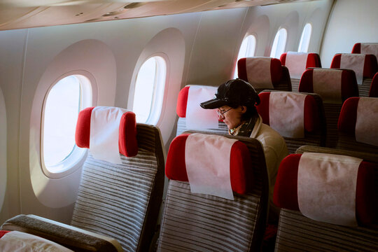 Person Sitting Alone on a Plane With Empty Rows Around