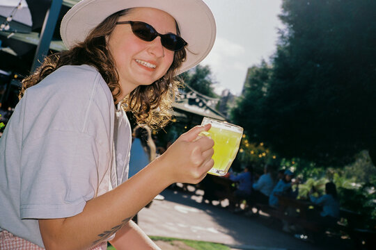 Woman drinks a refreshing drink and smiles to the camera 