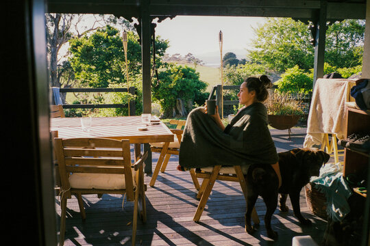 Woman sitting on a deck with a cup of coffee 