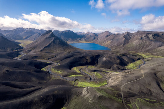F208 road winding through black volcanic plain to blue lake