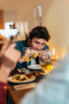 Man eating taco enjoying dinner with friends