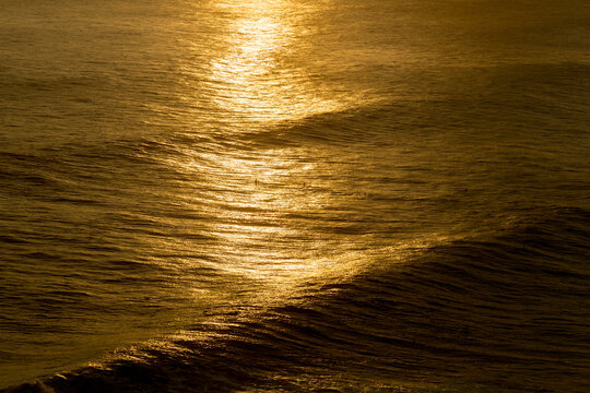 Golden light on ocean waves at sunset